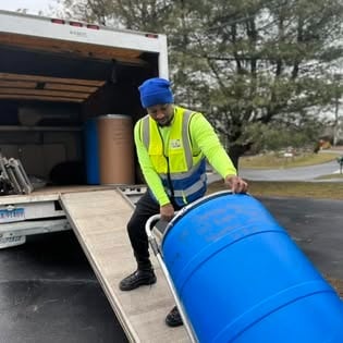 Shipping barrel on a hand truck at the back of the Afford It box truck