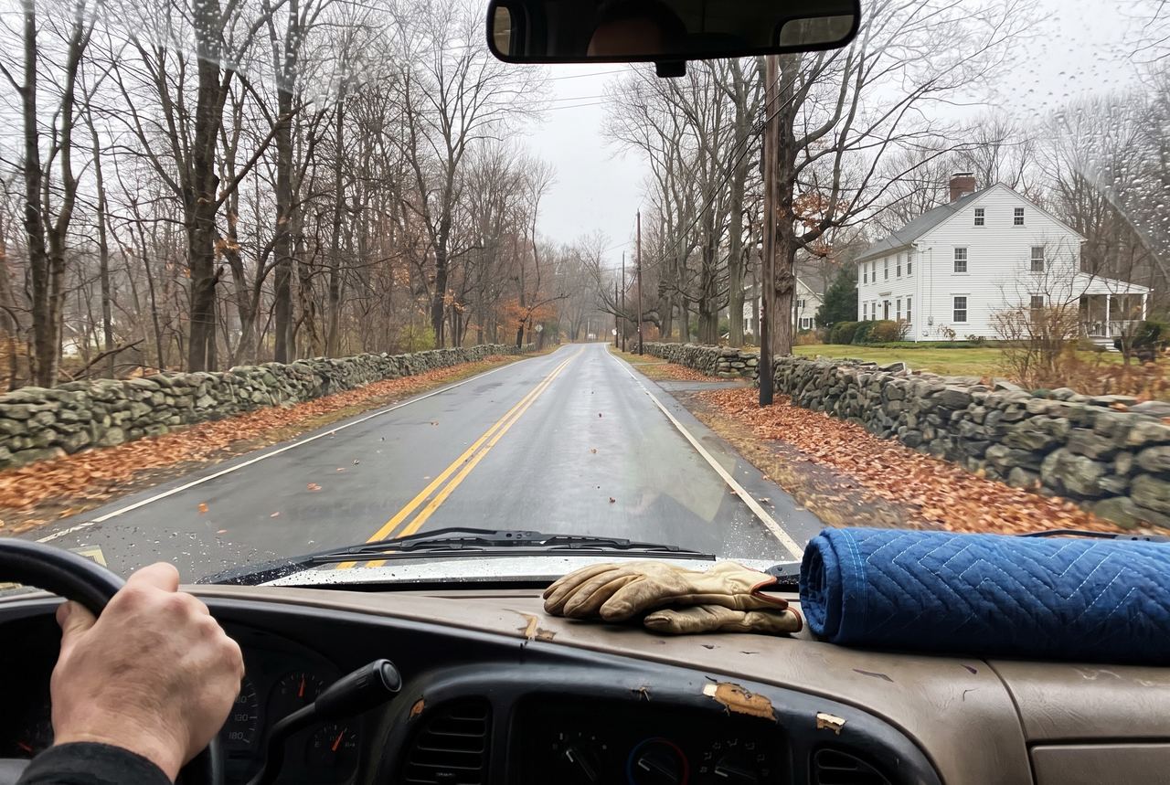 Driving a country road lined with stone walls on the way to a job in Fairfield County