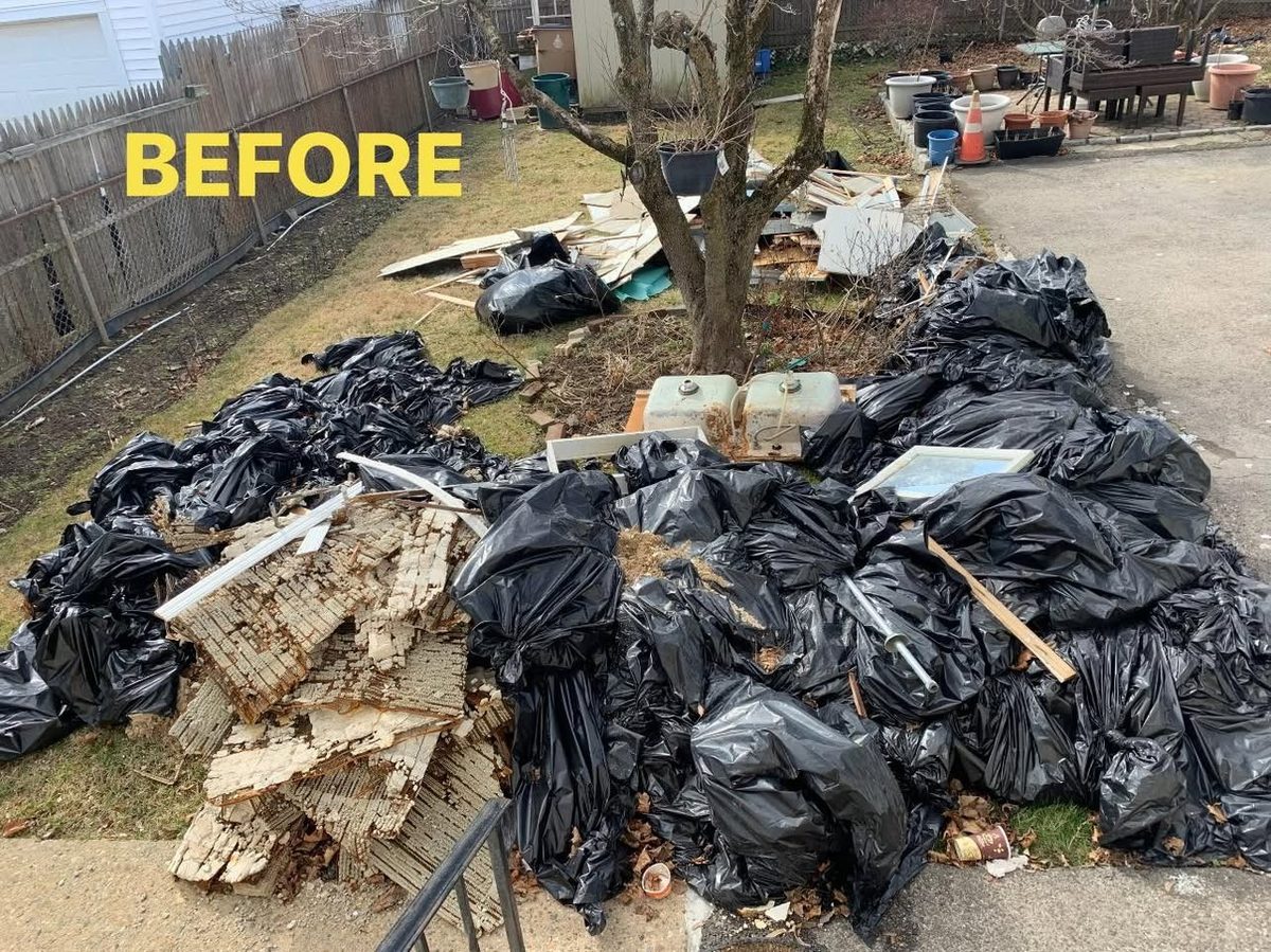 Before: a backyard covered in black trash bags, broken siding and old sinks